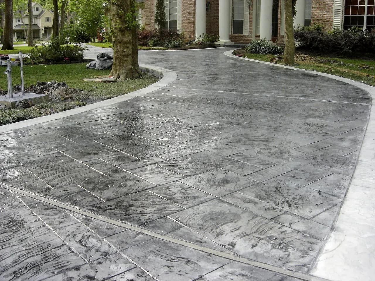A finished concrete driveway with clean edges in front of a two-car garage