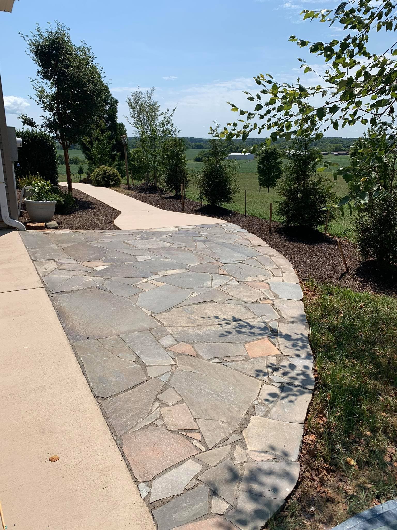 Stamped concrete patio with decorative pattern next to garden beds
